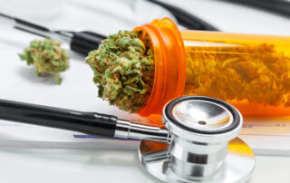 A medical marijuana bud in a container next to a stethoscope.